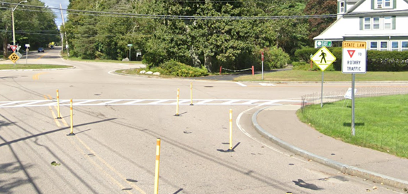 A view of an intersection with a sign that says "State Law Yield to Rotary Traffic".